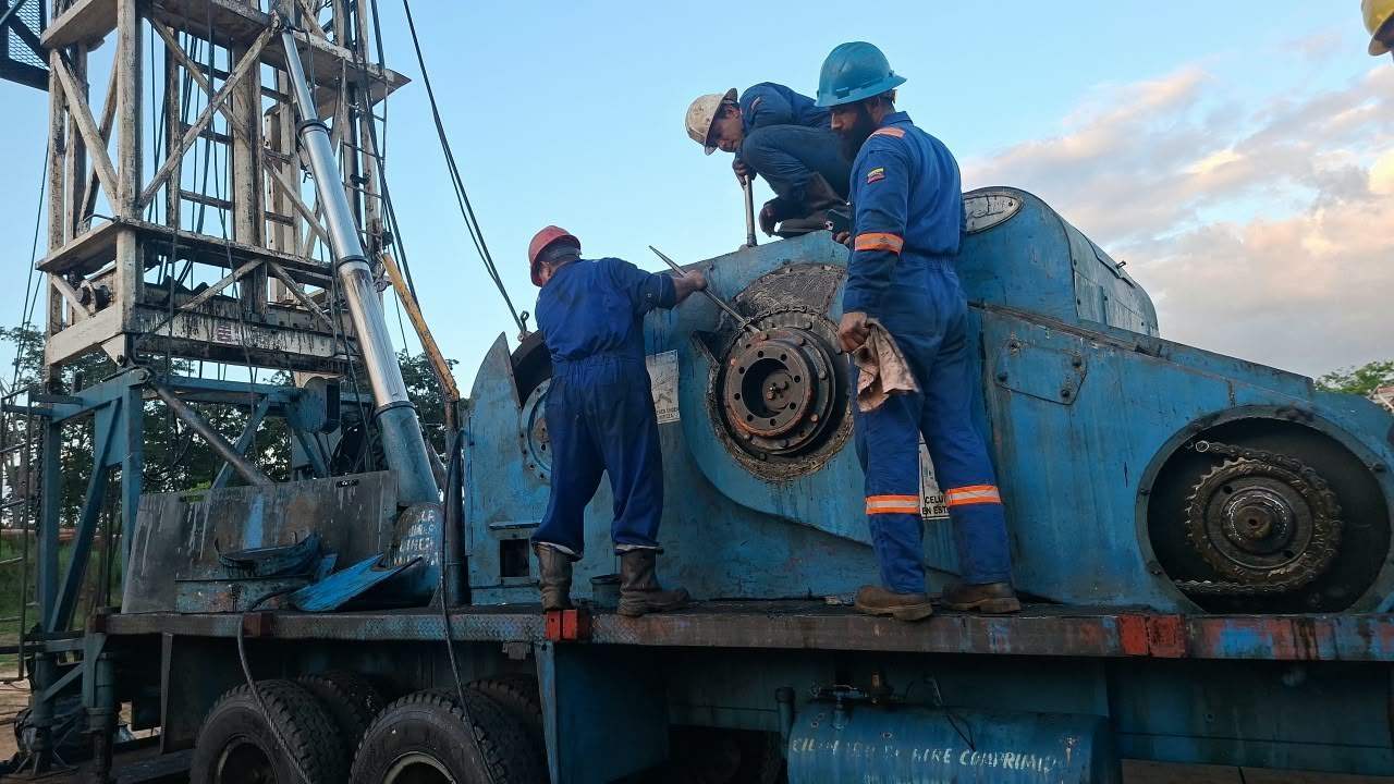 Técnicos trabajando sobre el malacate de un taladro