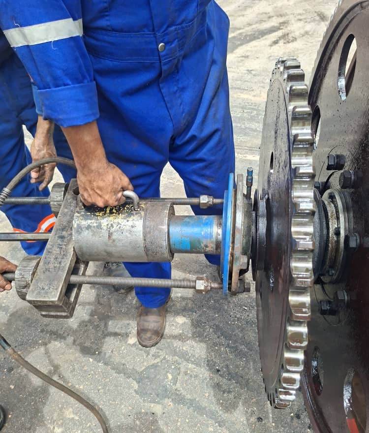 Técnico usando un extractor hidráulico en un piñón